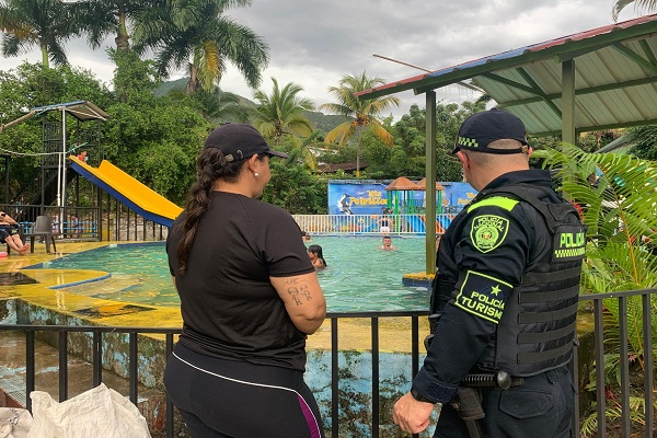 Un miembro de la Policía conversa e interactúa con una ciudadana en un espacio turistico