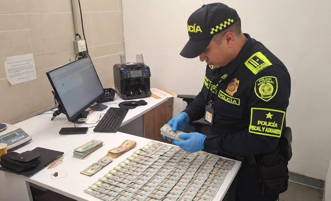 Funcionario de la polic&iacute;a fiscal y aduanera, realiza conteo de divisas no declaradas en el aeropuerto el dorado