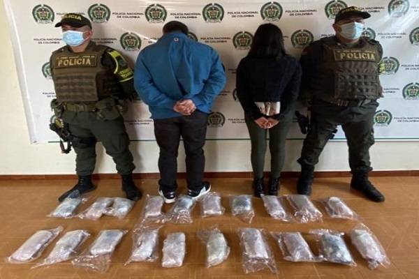 dos personas capturadas-policías custodiando-alucinógenos incautados