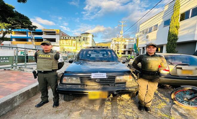 Dos uniformados de la Policía Nacional con un vehículo recuperado 