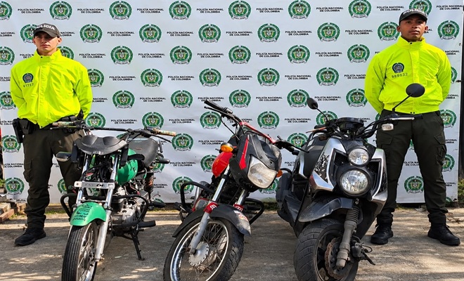 Tres motocicletas recuperadas por la Policía Nacional son exhibidas frente a un fondo institucional, custodiadas por dos uniformados en un procedimiento realizado en el departamento del Chocó