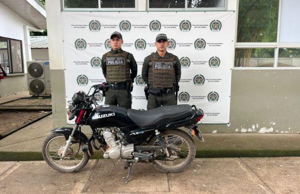 policías posando con la motocicleta recuperada 