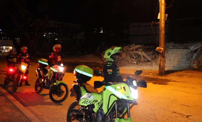 policías, motocicletas verdes y escombros del terremoto