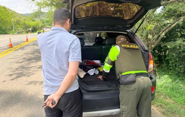 Un policía realizando registro a vehículo de un ciudadano