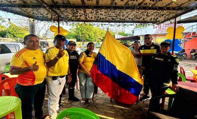 uniformados y ciudadanos sostienen la bandera de Colombia como símbolo de orgullo y amor