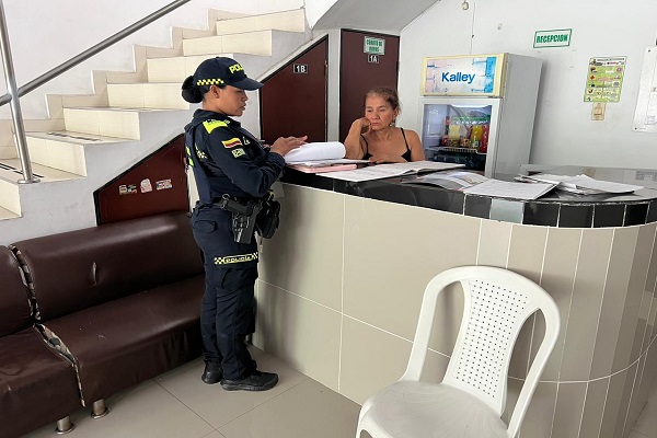 Policía de turismo verificando documentos de oficina de servicios turísticos